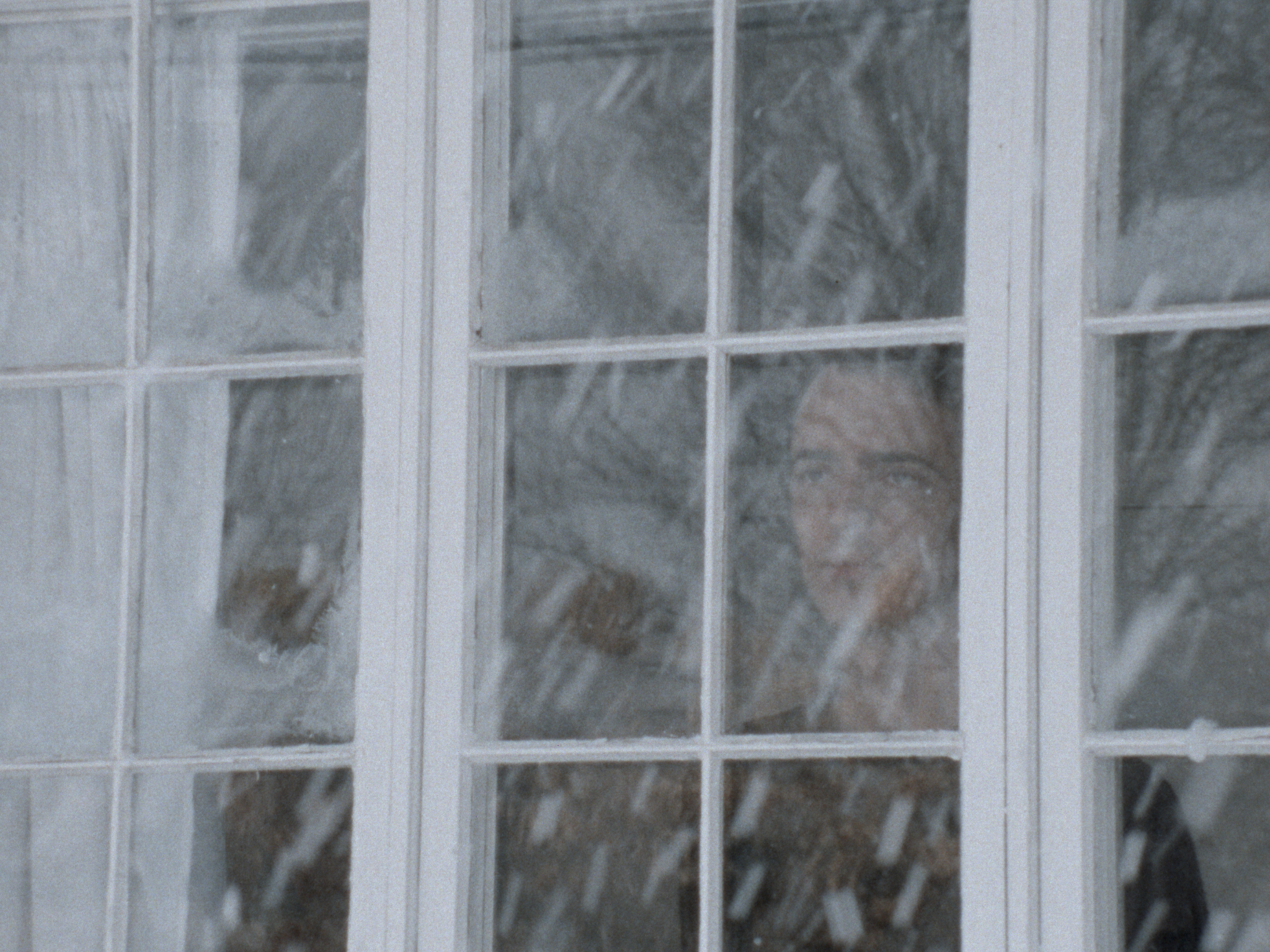 A Moment Is Enough scene still of protagonist looking at snow through window.