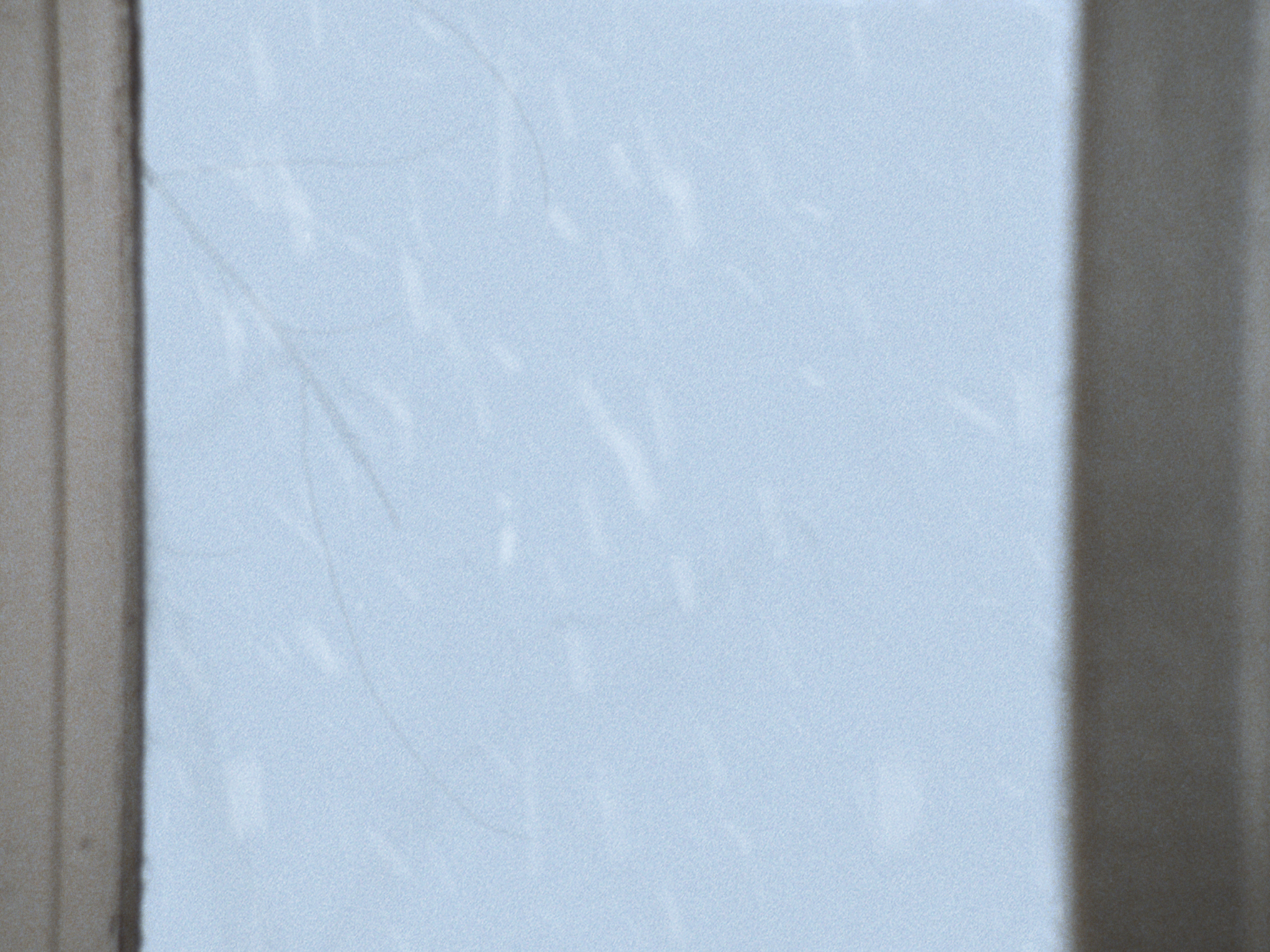 A still of snow blowing by an open gable door from A Moment Is Enough.